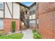 Charming exterior featuring a well-maintained brick facade, wooden staircase, and lush landscaping at 5323 Hansel Ave # E14, Orlando, FL 32809