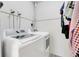 Bright laundry room with modern, white, front-loading washer and dryer and built-in shelving for optimal storage at 5323 Hansel Ave # E14, Orlando, FL 32809