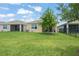 Backyard of a single Gathering home with a lush, green lawn at 5395 Sunshine Dr, Wildwood, FL 34785