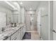 Bathroom featuring dual sinks with granite countertops and a glass-enclosed shower at 5395 Sunshine Dr, Wildwood, FL 34785