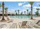 Relax by the community pool surrounded by palm trees and comfortable lounge chairs for residents at 5395 Sunshine Dr, Wildwood, FL 34785