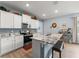 Kitchen features white cabinets, stainless steel appliances, granite countertops, and a central island with a sink at 5395 Sunshine Dr, Wildwood, FL 34785