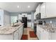 Open concept kitchen with granite countertops, white cabinets, stainless steel appliances, and a large island at 5395 Sunshine Dr, Wildwood, FL 34785