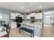Kitchen showcases white cabinets, stainless steel appliances, granite countertops, and a central island with seating at 5395 Sunshine Dr, Wildwood, FL 34785