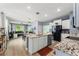 Open concept kitchen with granite countertops, white cabinets, stainless steel appliances, and a large island at 5395 Sunshine Dr, Wildwood, FL 34785