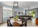Inviting living space with a dark sectional sofa, a dining table, and large windows that fill the room with natural light at 5395 Sunshine Dr, Wildwood, FL 34785