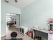 Bright room featuring light blue walls, wood-look floors, and a functional desk, ideal for a home office or study area at 5395 Sunshine Dr, Wildwood, FL 34785