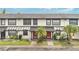 Charming townhome with a red door, a well-kept lawn and beautiful palm trees at 5662 Royal Pine Blvd # 24, Orlando, FL 32807