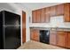 Functional kitchen features wood cabinets, black appliances, and tiled floors at 5662 Royal Pine Blvd # 24, Orlando, FL 32807