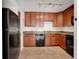 A kitchen with wood cabinets, black appliances, and tile floors at 5662 Royal Pine Blvd # 24, Orlando, FL 32807