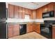 Well-equipped kitchen with wood cabinets and black appliances at 5662 Royal Pine Blvd # 24, Orlando, FL 32807