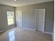 This cozy bedroom features tile flooring, a large window, neutral paint and two entryways at 607 Escondido Ct, Kissimmee, FL 34758
