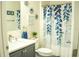 Well-lit bathroom featuring a modern vanity, decorative mirrors, and a stylish shower curtain at 608 Washington Way, Haines City, FL 33844