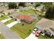 Aerial view features a gray single Gathering home with a terracotta roof, a screened pool and an attached two-car garage at 611 Jura Ln, Kissimmee, FL 34759