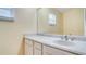 Bathroom vanity with white cabinets, sink, chrome faucet, and large mirror at 611 Jura Ln, Kissimmee, FL 34759