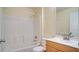 Well-maintained bathroom features a shower-tub combo, white tile surround, and wood vanity with a white sink at 611 Jura Ln, Kissimmee, FL 34759