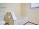Bright bathroom features a white tiled soaking tub and toilet with tiled floor trim at 611 Jura Ln, Kissimmee, FL 34759