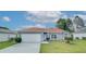 Charming single-story home with well-maintained lawn and attached two-car garage on a sunny day at 611 Jura Ln, Kissimmee, FL 34759