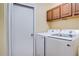 The laundry room features a modern washer and dryer set, with convenient overhead storage cabinets at 611 Jura Ln, Kissimmee, FL 34759