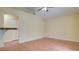 An empty living room space has tile floors, light yellow walls, and a ceiling fan, ready for customization at 611 Jura Ln, Kissimmee, FL 34759