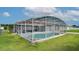 Screened-in pool area includes modern outdoor furniture, a built-in pool, and a manicured lawn for relaxation at 611 Jura Ln, Kissimmee, FL 34759