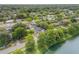 Aerial view of a lovely neighborhood with mature trees and a home with a swimming pool bordering a lake at 614 S Amelia Ave, Deland, FL 32724