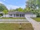 Charming single-story home featuring a white picket fence, well-manicured lawn, and attached one-car garage at 614 S Amelia Ave, Deland, FL 32724