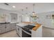 Updated kitchen with marble countertops, gray cabinets, stainless steel appliances, and a breakfast bar for seating at 614 S Amelia Ave, Deland, FL 32724