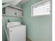 A separate laundry room featuring a white washer and storage cabinets at 614 S Amelia Ave, Deland, FL 32724