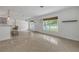 Bright living room with terrazzo floors, a white interior, and natural light streaming through the windows at 614 S Amelia Ave, Deland, FL 32724