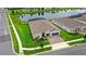 Aerial view of a modern home with a two-car garage, paved driveway, lush lawn and a serene pond at 6348 Mossy Oak Rd, St Cloud, FL 34771