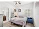 Bright bedroom with a cozy bed, two blue nightstands, a large window, and a view into an ensuite bath at 6348 Mossy Oak Rd, St Cloud, FL 34771