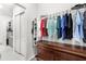 Well-organized closet space featuring hanging clothes, shelving, and a wooden dresser at 6348 Mossy Oak Rd, St Cloud, FL 34771