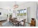 Bright dining room featuring a wood table, chandelier, and large window overlooking the screened lanai and water view at 6348 Mossy Oak Rd, St Cloud, FL 34771