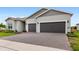 Charming home exterior with a three-car garage and paver driveway at 6348 Mossy Oak Rd, St Cloud, FL 34771
