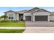 Well-maintained home exterior featuring a two-car garage, paver driveway, and manicured landscaping at 6348 Mossy Oak Rd, St Cloud, FL 34771