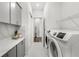 Functional laundry room with modern appliances, gray cabinets, countertop space, and a wire rack at 6348 Mossy Oak Rd, St Cloud, FL 34771