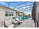 Comfortable outdoor seating and dining on screened patio with ceiling fans at 6348 Mossy Oak Rd, St Cloud, FL 34771
