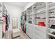 Spacious walk-in closet with ample shelving, hanging rods, drawers, and a comfortable ottoman at 6348 Mossy Oak Rd, St Cloud, FL 34771
