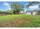 Expansive backyard with green lawn, mature tree, fenced perimeter, and white home with covered patio visible at 6505 Dorchester Rd, Lakeland, FL 33809