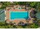 Aerial shot of the pool, featuring a hot tub, lounge chairs, and umbrellas at 7509 Mourning Dove Cir # 302, Reunion, FL 34747