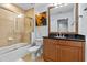 A bathroom with a shower over tub and a single sink vanity with dark wood cabinets at 7509 Mourning Dove Cir # 302, Reunion, FL 34747