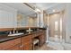 Bathroom featuring a dual sink vanity with granite countertop and glass enclosed shower at 7509 Mourning Dove Cir # 302, Reunion, FL 34747