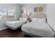 Bright bedroom featuring two twin beds with matching headboards and vinyl wood floors at 7509 Mourning Dove Cir # 302, Reunion, FL 34747