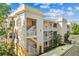 Beautiful condo building featuring balconies and a well-maintained facade with stucco and painted trim details at 7509 Mourning Dove Cir # 302, Reunion, FL 34747
