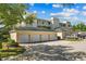 View of the garages with white doors and a well-manicured lawn in front of the condo building at 7509 Mourning Dove Cir # 302, Reunion, FL 34747
