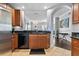 Bright kitchen with sleek appliances, wooden cabinetry, dark countertops, tile floor and open view to living space at 7509 Mourning Dove Cir # 302, Reunion, FL 34747