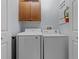 Convenient laundry room with Samsung washer and dryer and upper cabinet storage at 7509 Mourning Dove Cir # 302, Reunion, FL 34747