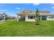 Expansive backyard with well-maintained grass and view of the home's exterior at 8106 Mabury Ln, Orlando, FL 32832