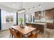 Modern kitchen and dining area featuring dark cabinetry, granite countertops, and stylish pendant lighting at 8106 Mabury Ln, Orlando, FL 32832